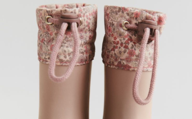 Pair of floral-patterned rain boots with drawstring on a light gray background